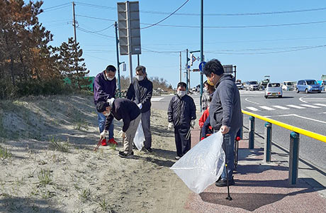 海岸沿いに捨てられたごみを1つずつ回収していく