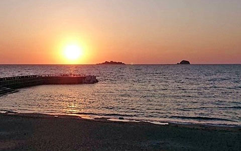 高浜海水浴場から望む夕日を背負った軍艦島
