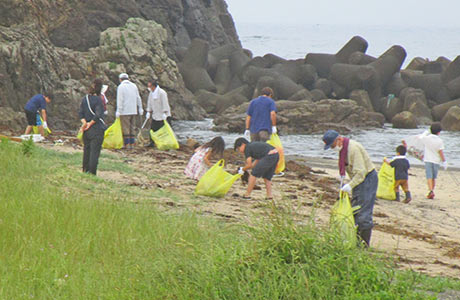 海岸に漂着したごみを集める参加者たち